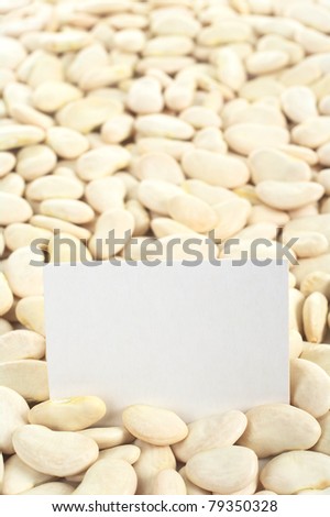 Dried raw butter bean or also called lima bean (lat. Phaseolus lunatus) with a blank card (Selective Focus, Focus on the card)