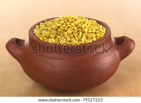 Raw pearl barley in rustic bowl on wood (Selective Focus, Focus on the pearl barley in the front)