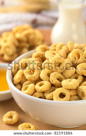 A bowl full of honey flavored cereal loops (Selective Focus, Focus on the standing cereal loop in the middle of the bowl)