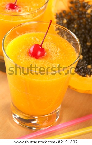 Fresh blended papaya juice garnished with a maraschino cherry (Selective Focus, Focus on the cherry)