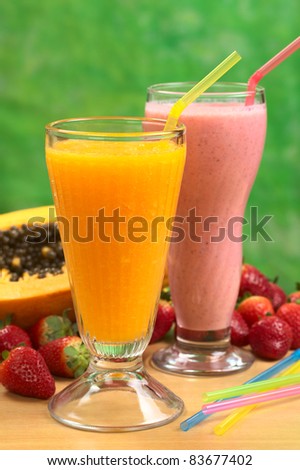Papaya juice and strawberry milkshake with straws (Selective Focus, Focus on the straw in the papaya juice)