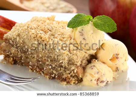 Apple crisp made of oatmeal and apple served with ice-cream and mint leaf (Selective Focus, Focus on the mint leaf and the front of the upper ice-cream ball)