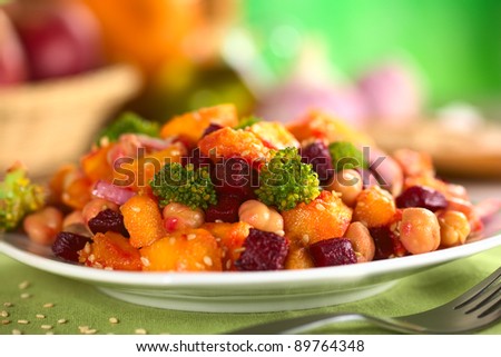 Pumpkin, beetroot, broccoli and chickpea salad garnished with sesame seeds (Selective Focus, Focus on the two broccoli florets in the front and the vegetable around)