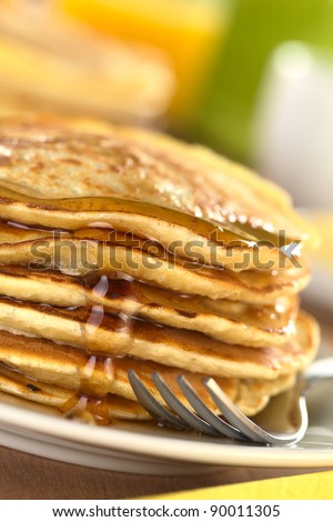 Fresh homemade pancakes with maple syrup (Selective Focus, Focus on the syrup drop running down)