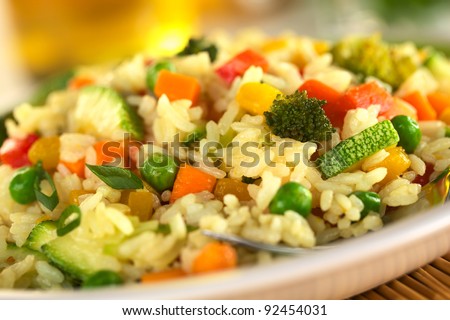 Vegetable risotto made of zucchini, pea, carrot, red bell pepper, broccoli and pumpkin (Selective Focus, Focus in the middle of the image)