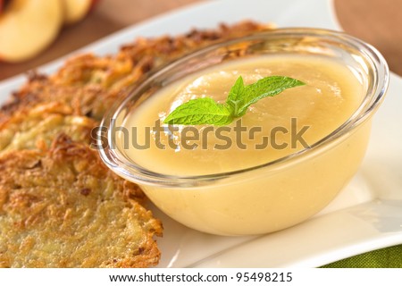 Apple sauce with potato fritters (Selective Focus, Focus on the mint leaf on the apple sauce)