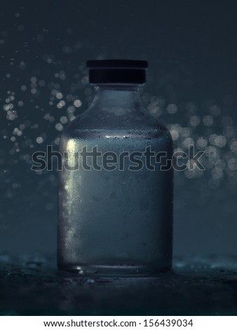Single medical ampoule with studio light background and water drops
