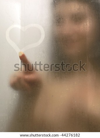 stock photo Beautiful woman taking a shower and drawing heart on the sweat