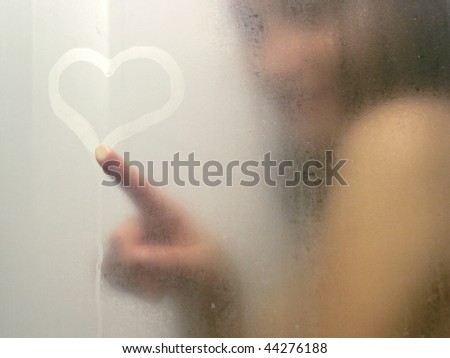 stock photo Beautiful woman taking a shower and drawing heart on the sweat 