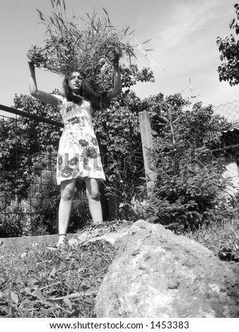 Woman throwing grass in air in a garden - black and white