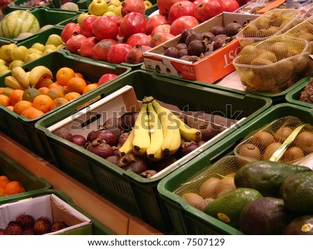 Fruits in a supermarket - pomegranates, oranges,  quinces, melons, watermelons, bananas, apples, kiwis, mangos and others, clearly visible in the picture.