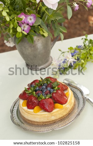 Vertical shot looking down on fruit dessert and flower bouquet