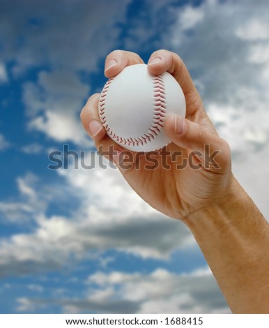 man\'s hand gripping baseball,sky in background,pitchers grip
