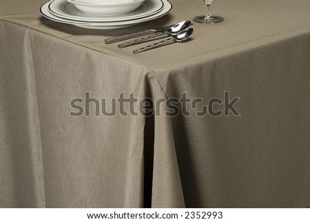 table setting showing linen table cloth, dishes and silverware