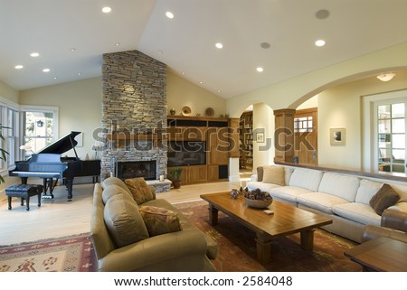 living room in custom home,stone fireplace,grand piano,big screen,archways,contemporary furnishings