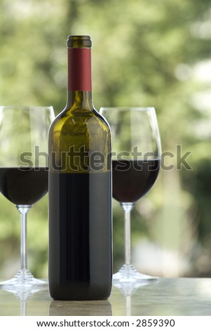 open bottle with two glasses on marble surface, outdoor background
