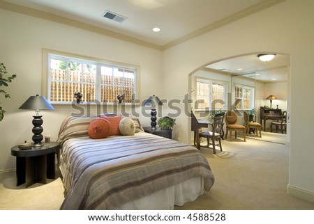 bedroom interior,bed,tables,lamps,adjacent sitting room,closet mirror and small desk,windows