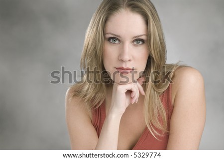 beautiful young woman, staring right at you with a confident relaxed expression, resting on her right hand,copy space