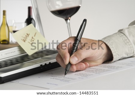 filling out order form,laptop,glass,hand holding pen
