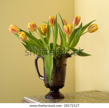 bouquet of tulips in a vintage purple glass pitcher, yellow walls