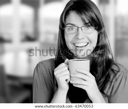 young woman enjoying here cup of coffee, indoors, visible steam coming from cup