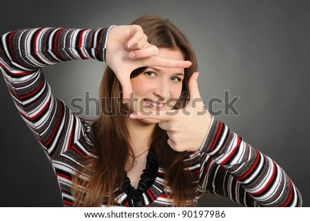 Portrait of a beautiful young woman creating a frame with her hands