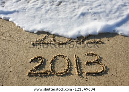 2013 written in the sand with 2012 washed away by the surf.