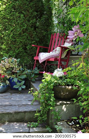 Colorful rocking chair in a cottage garden setting.