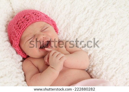One week old newborn baby girl crying.