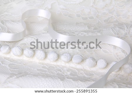 Close up of a lace overlay wedding dress. Shallow depth of field, focus on the center.