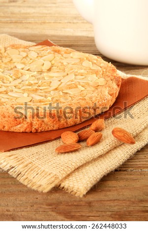 Dutch almond cake on a wooden table with slivered almonds on top. Also available in horizontal.