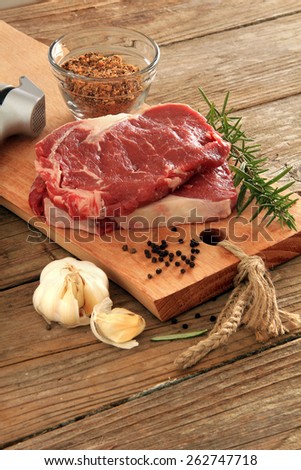 Raw prime rib beef steaks with spices, garlic and rosemary. Also available in horizontal.