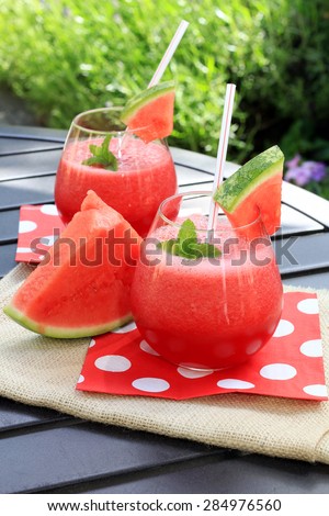 Watermelon drinks outside in the garden with straws and fresh mint.