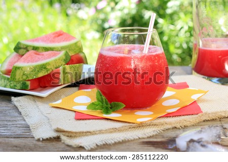 Watermelon drinks outside in the garden with straws and fresh mint. Also available in vertical.