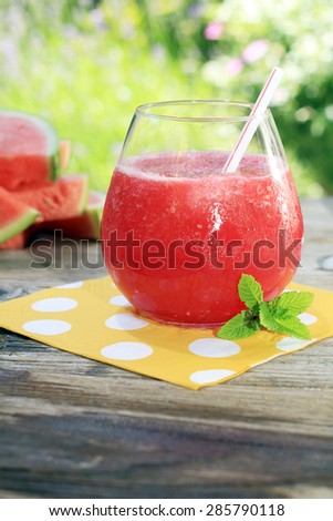 Watermelon drinks outside in the garden with straws and fresh mint.Also available in horizontal.