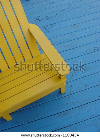Yellow adirondack chair on blue deck