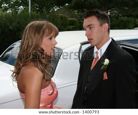 Young couple in formal wear in front of a limousine