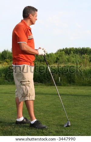 Man waiting for his turn to tee off at the golf course.