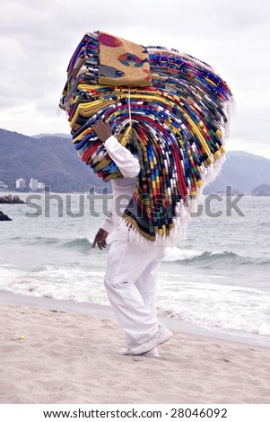 Vendor on the beach selling mexican blankets.