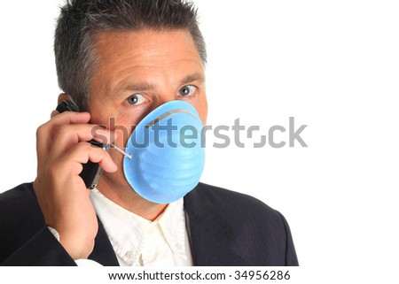 Man on the phone while wearing a flu mask.