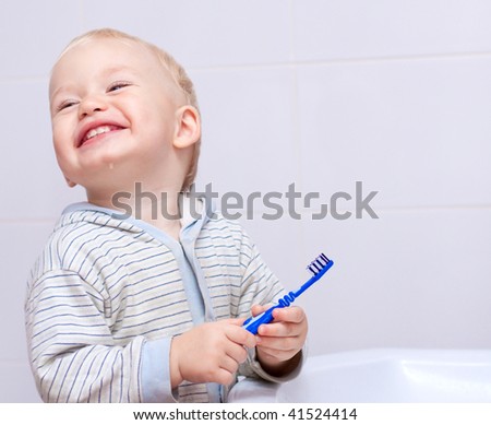 Cute little boy cleans his teeth in bathroom