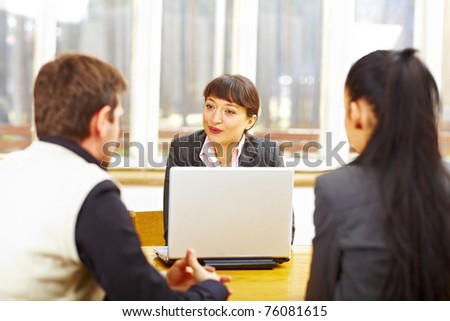 Female consultant advising couple sitting at the computer