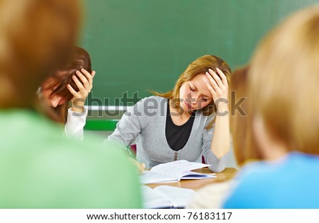 Students at the desk with notebook, struggling with school work