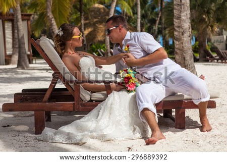 husband and wife relaxing on sunbeds at the beach.