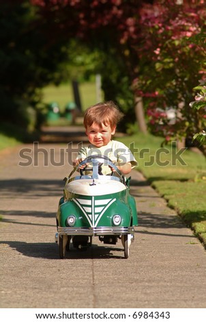 boy driving pedal car