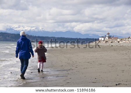 Mother and child walking on beach at Discovery Park, Seattle, USA