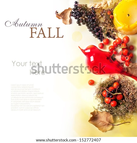 Autumn card with glass red bird, autumn berries and yellow candle over white with sample text