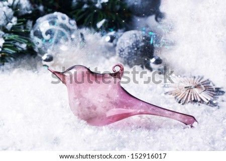 Christmas toy pink glass bird on snow with christmas tree and silver balls