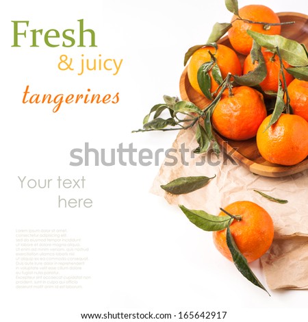 Wooden plate of tangerines with leaves on crumpled paper over white with sample text