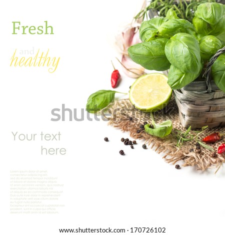 Bunch of fresh basil, bowl of walnuts, pepper, garlic and glass bottle of olive oil served on white wooden table. See series